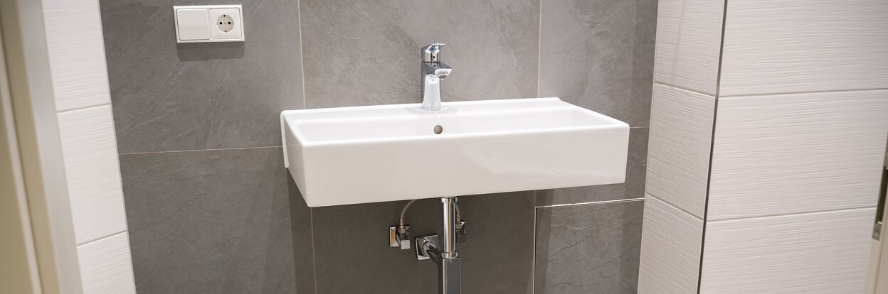 weißes, eckiges waschbecken in einem neuen bad